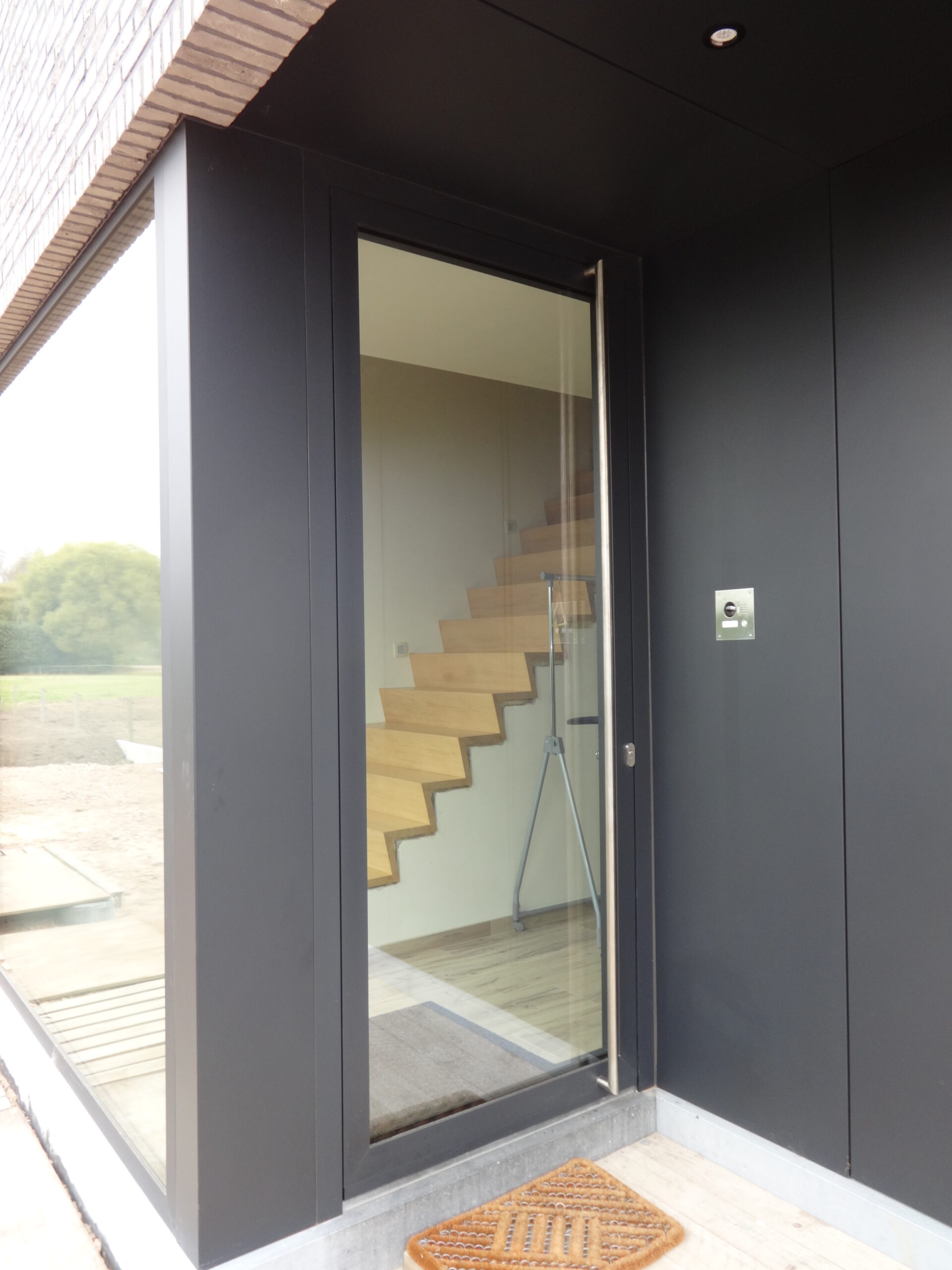 Heldere beglaasde deur met inox trekke